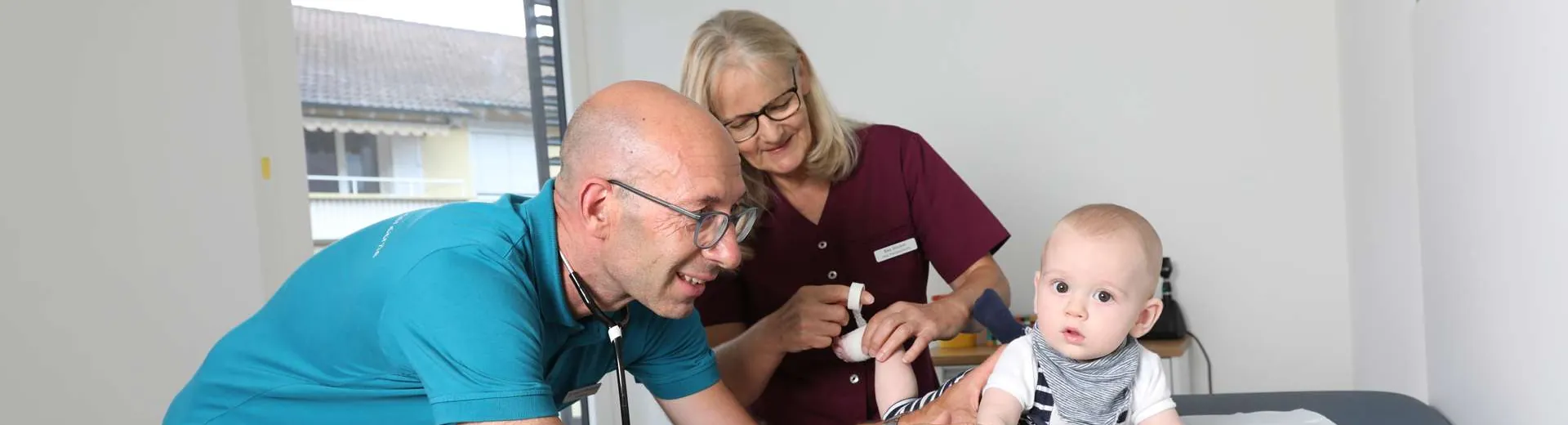 Kinderarzt und medizinische Praxisassistentin bei einem Hörtest mit einem Säugling